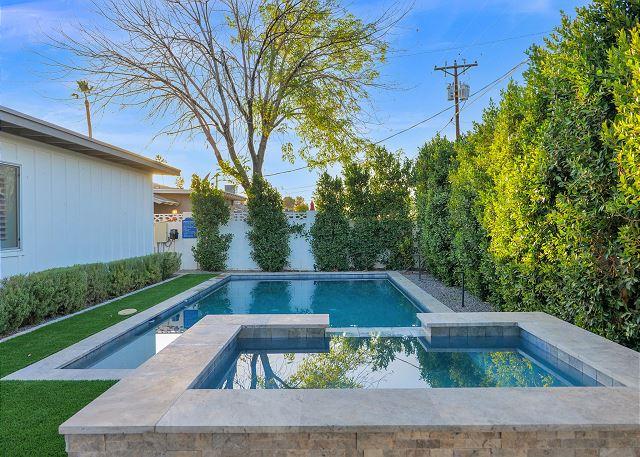 Private putting green surrounded by manicured landscaping at Entertainers Oasis