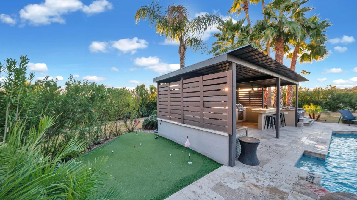 Private putting green surrounded by manicured landscaping at Entertainers Oasis