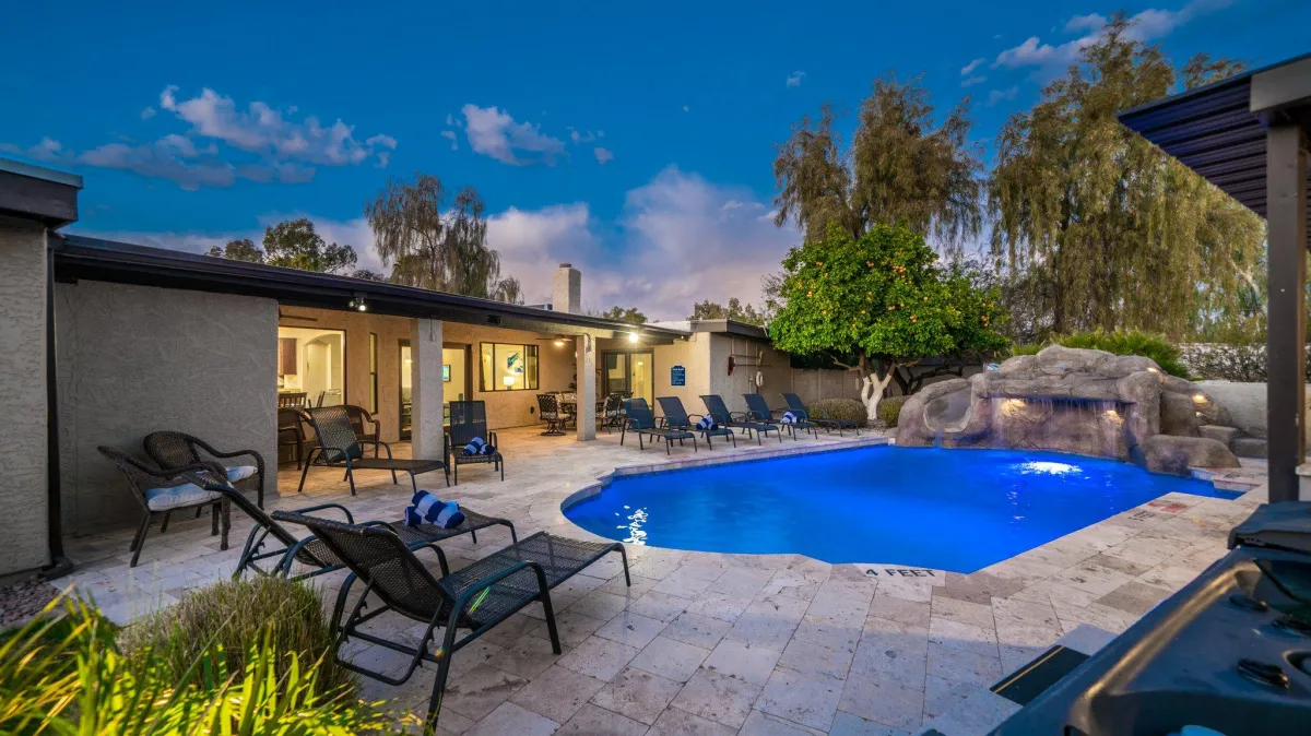 Nighttime view of the pool and patio with ambient lighting
