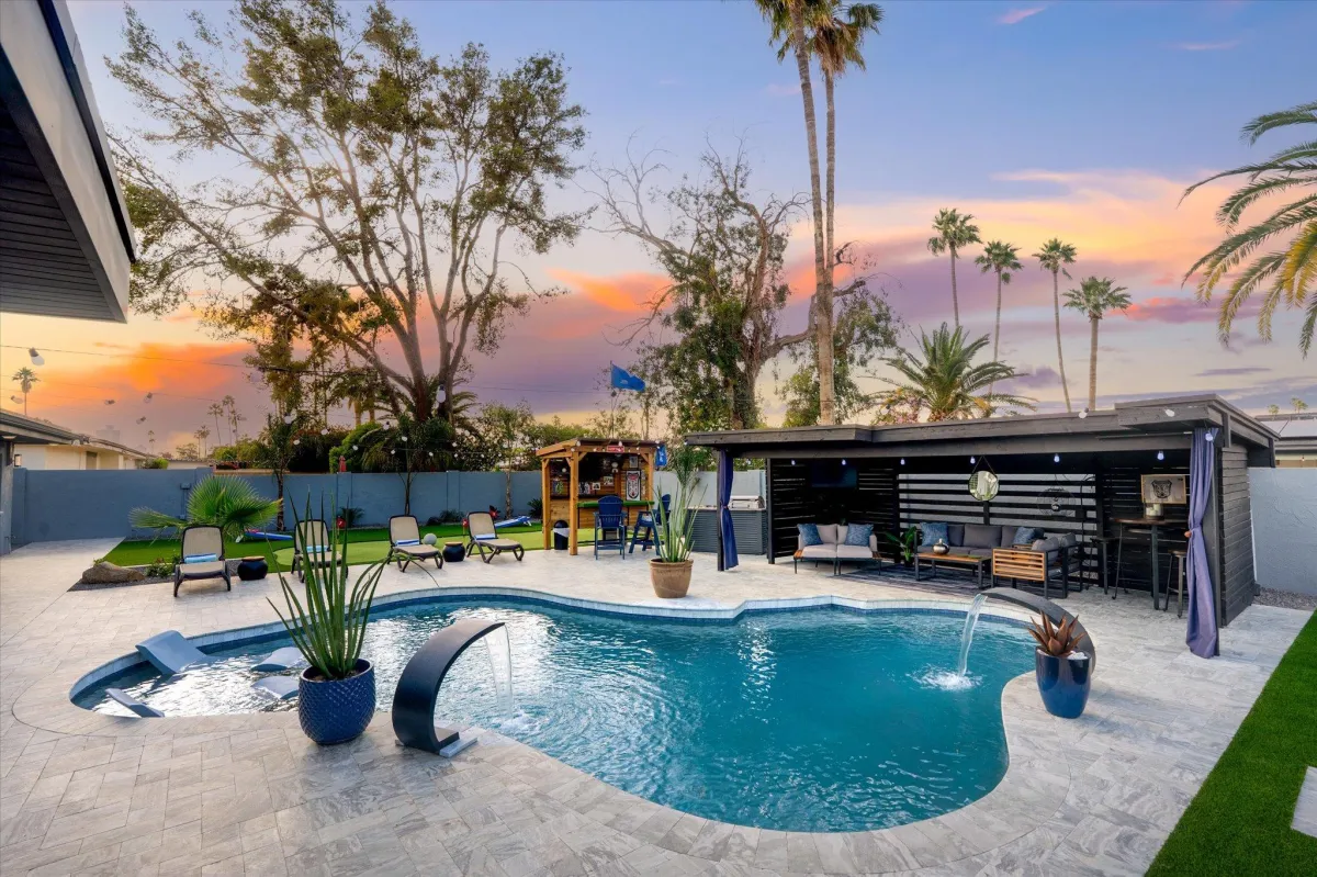 Covered outdoor dining area with grilling station and lounge seating