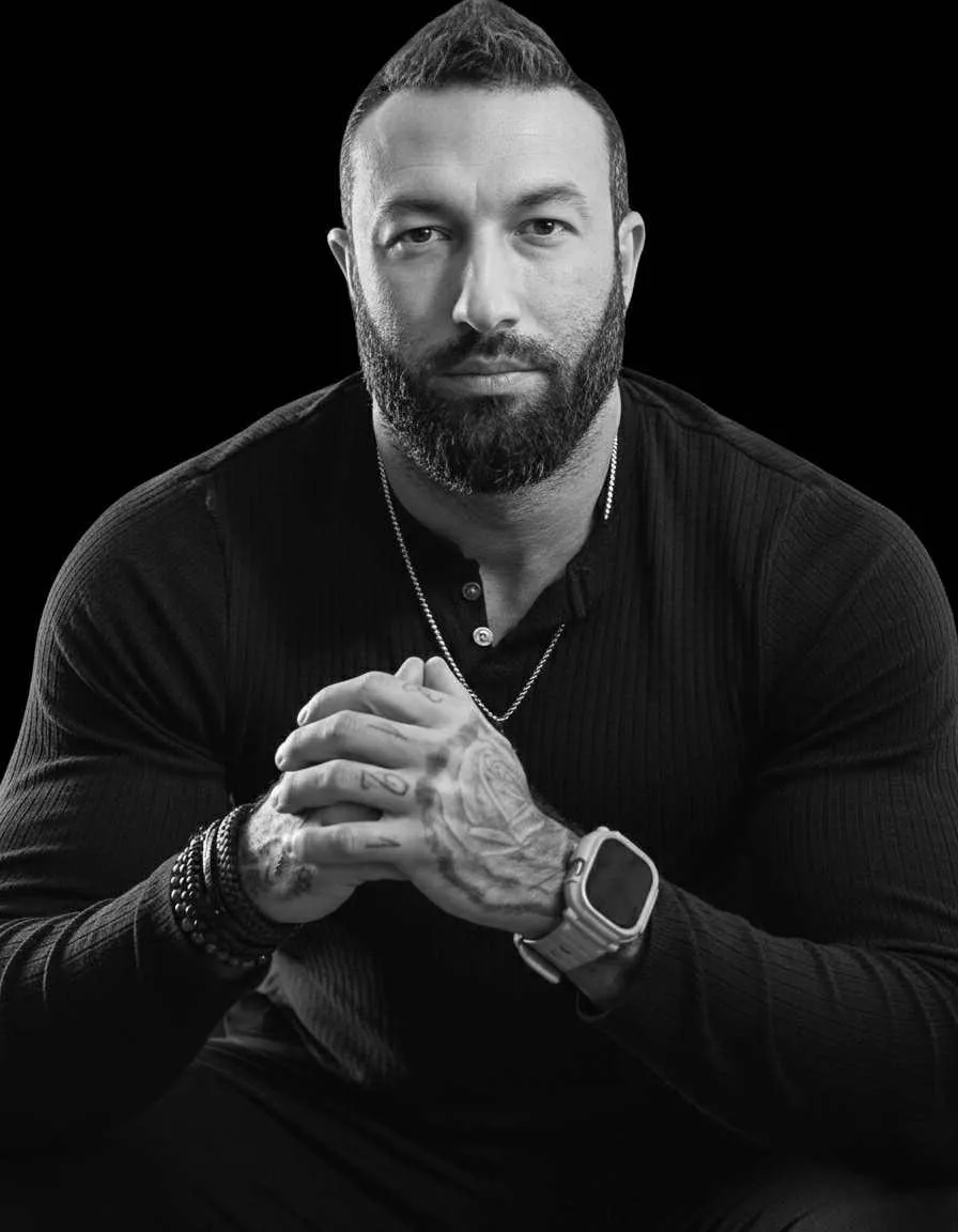 A diverse team of three marketing professionals collaborating at a bright office table, reviewing campaign materials and smiling. The workspace features large windows, greenery, and modern decor, emphasizing teamwork and approachability. 3:2 aspect ratio.