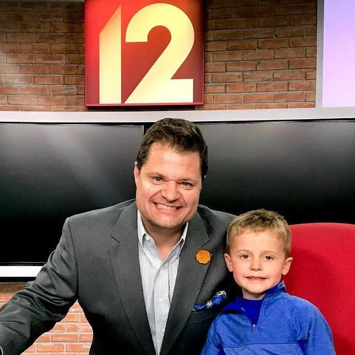 Storm and his son Harry posing at the Local 12 - CBS news desk.