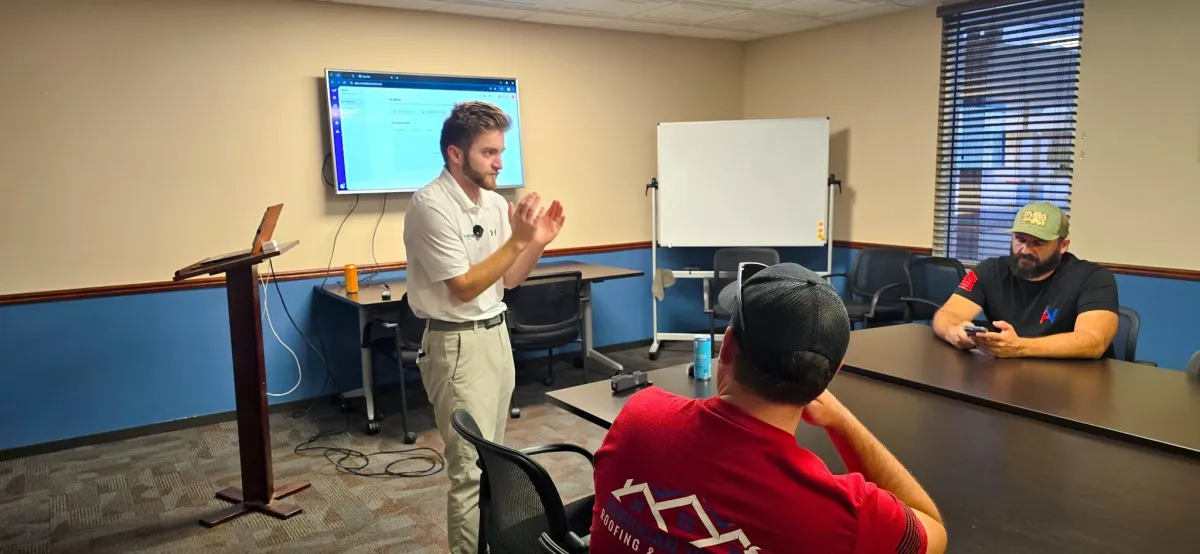 Blonde woman in glasses presenting near flip chart