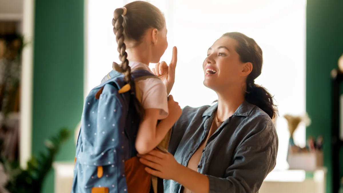 Criança sendo cuidada pelos pais em casa após voltar da escola, representando atenção à saúde infantil