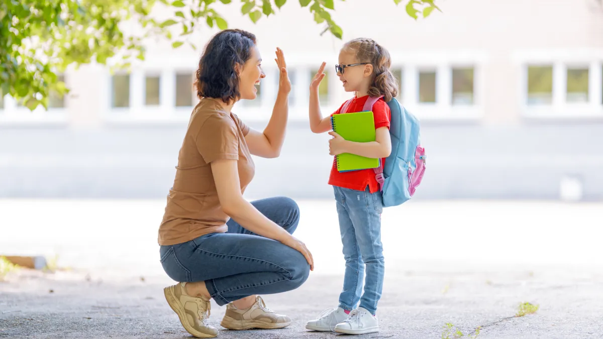 Criança se despedindo dos pais com acolhimento, representando vínculo e segurança emocional.