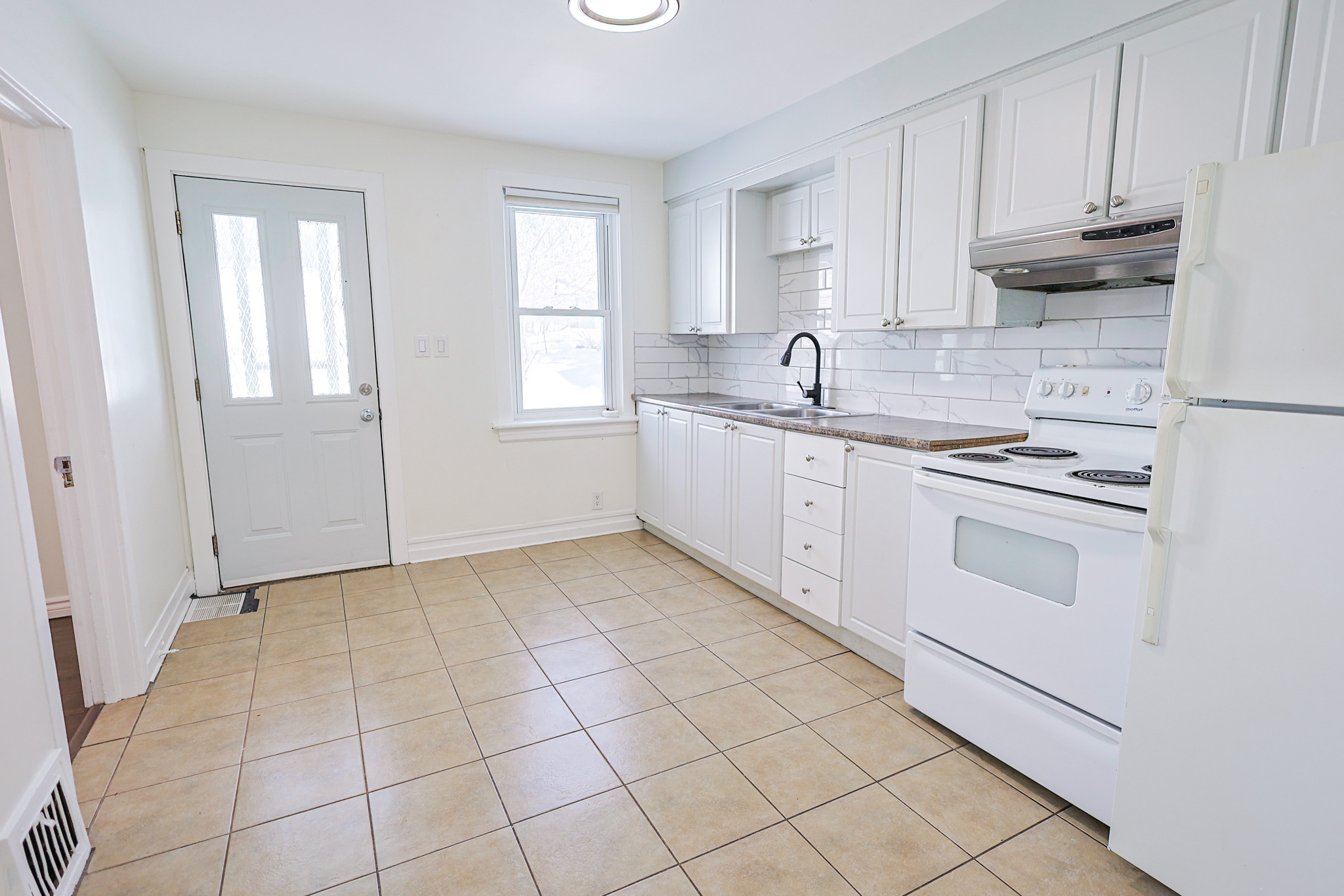 a living room filled with furniture and a kitchen