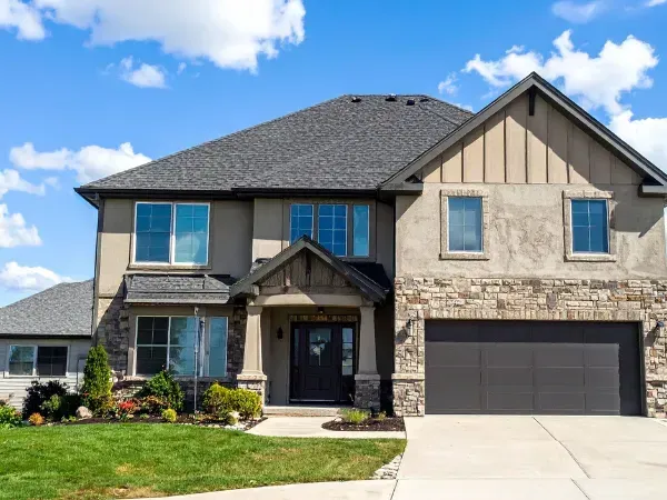 Contemporary suburban two-story house with a concrete driveway and landscaped front yard