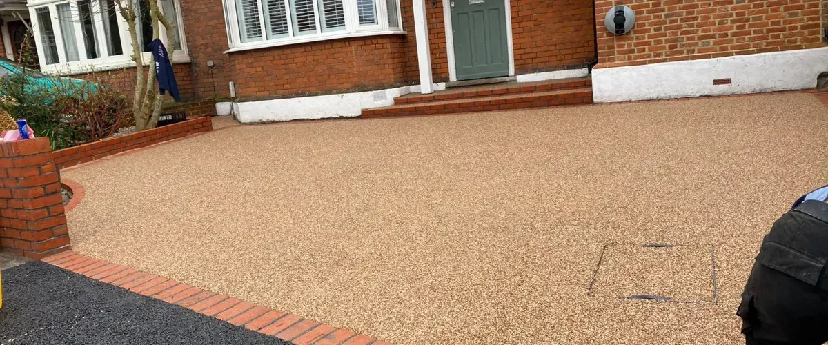 Clean, freshly paved resin-bound driveway in front of a brick house