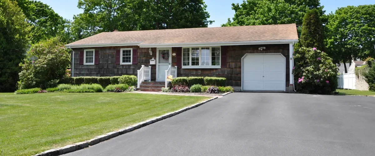 Front view of a suburban home with a well-kept lawn and clean driveway