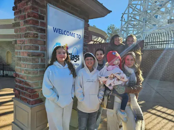 Family photo of Spiffy Clean owners and kids at an amusement park.