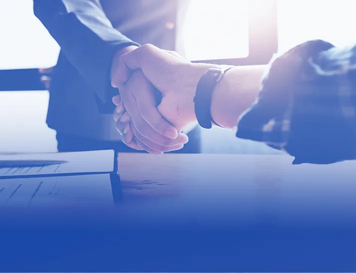 Two investors shaking hands to close a successful real estate deal, representing the process to find, fund, and close winning investments at the Grant Cardone Real Estate Summit.