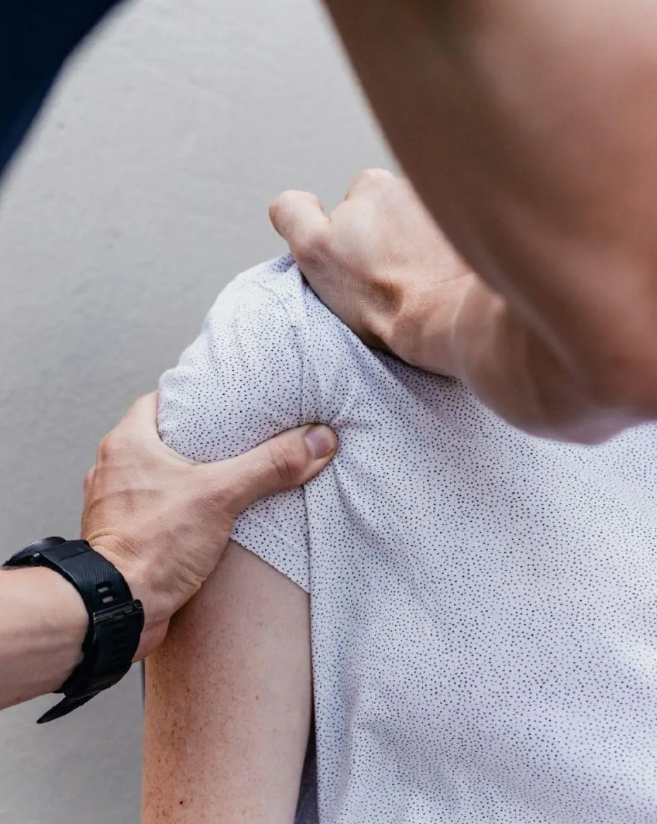 Illustration of a practitioner treating a patient`s shoulder with myofascial releases.