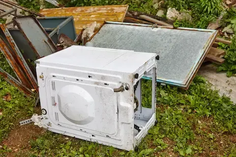 Old appliance disposal with metal scrap scattered on the ground – Woodburn Junk Removal.