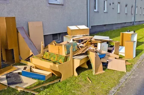 Commercial junk removal with broken furniture stacked outside – Woodburn Junk Removal.