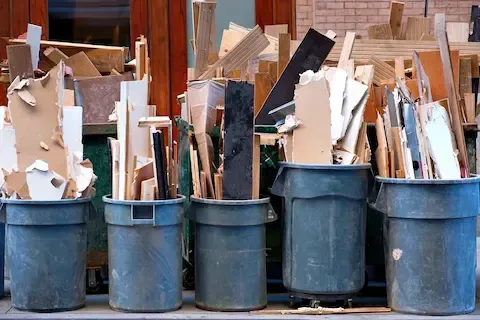 Construction debris packed in bins during cleanup – Woodburn Junk Removal.