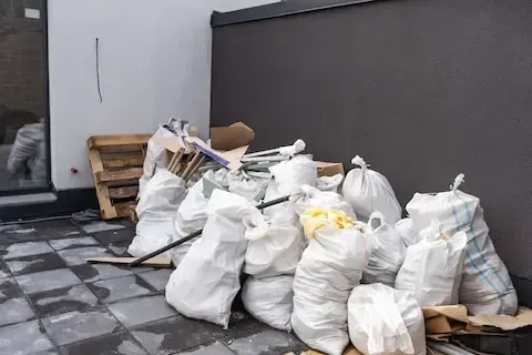 Residential junk cleanout with bagged debris and discarded materials – Woodburn Junk Removal.