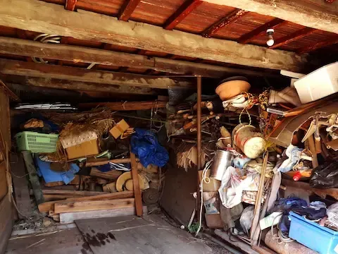 Garage cleanout with heavy clutter and stored items filling the space – Woodburn Junk Removal.