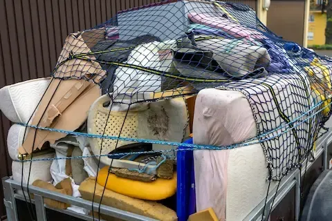 Estate cleanout hauling trailer filled with old furniture and junk – Woodburn Junk Removal.