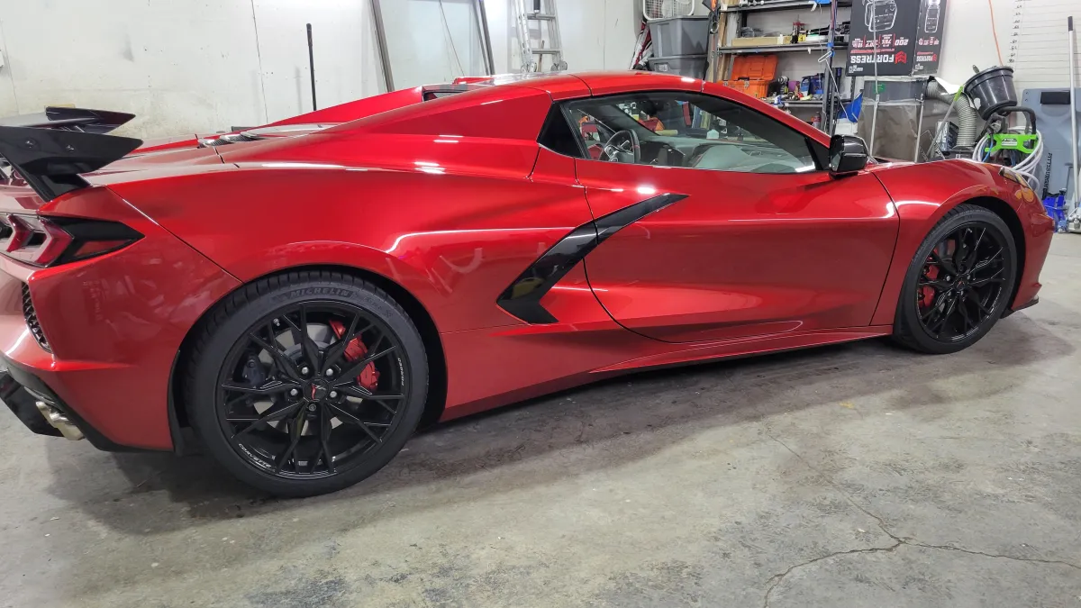 Red Corvette C8 sports car in a detailing garage, showcasing high-quality paint protection and ceramic coating services by Alpha Shielding LLC in Bend, Oregon.