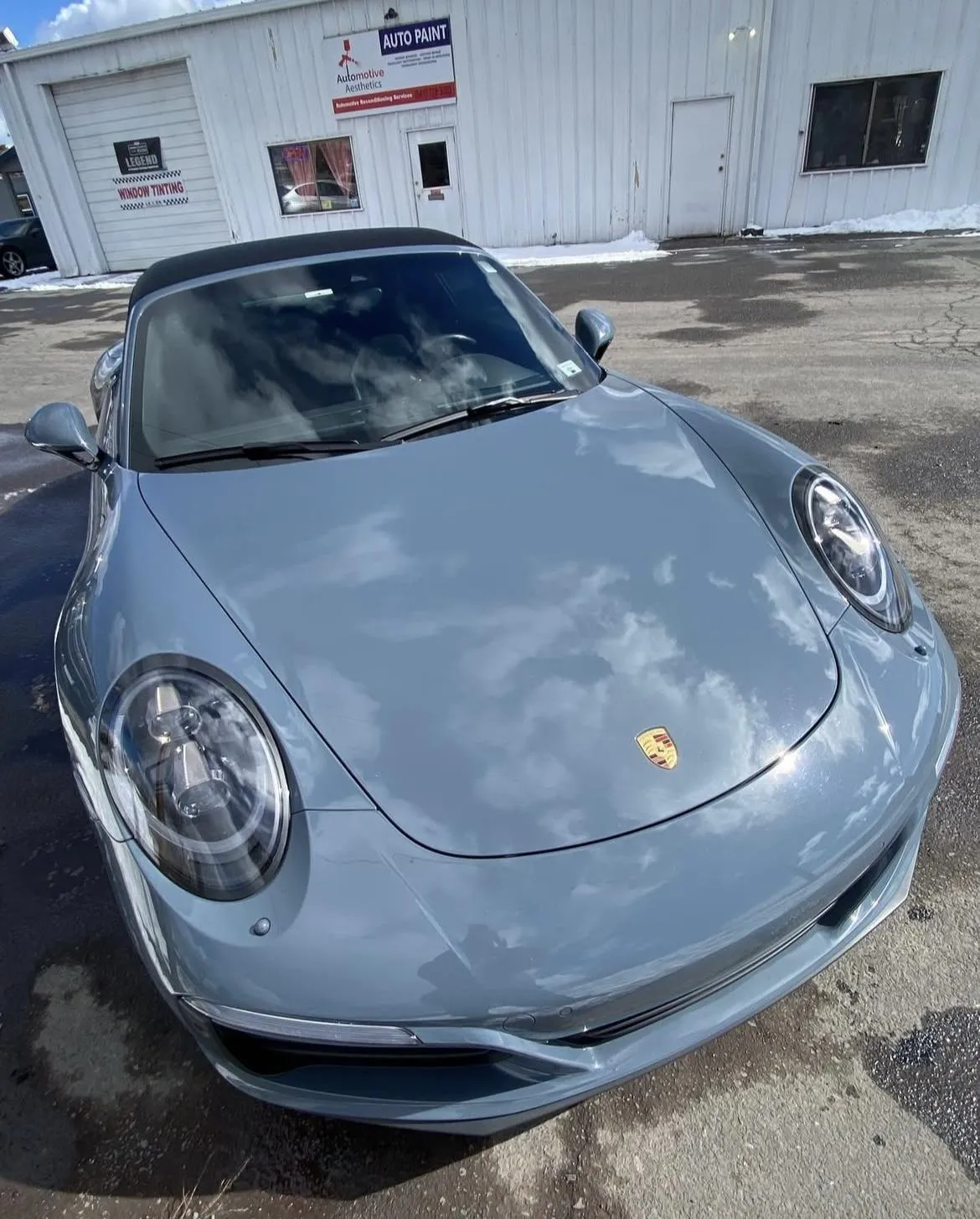 Porsche sports car with sleek gray exterior and polished finish, parked outside Alpha Shielding LLC, showcasing expert auto detailing and paint protection services in Bend, Oregon.