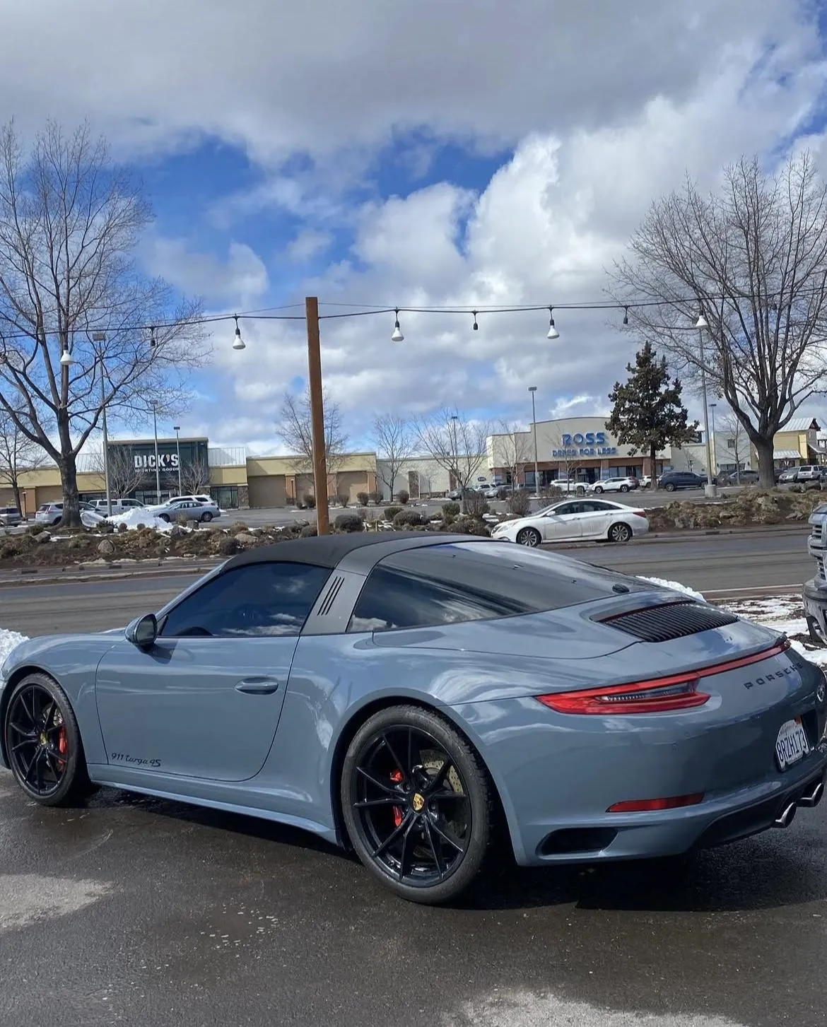 Porsche sports car with sleek gray exterior and polished finish, parked outside Alpha Shielding LLC, showcasing expert auto detailing and paint protection services in Bend, Oregon.