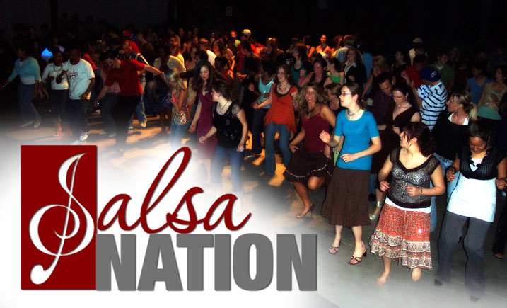 A candid group photo of original Salsa Nation members, diverse in age and background, laughing together in a sunlit park. The group is mid-conversation, some holding dance shoes, radiating warmth and camaraderie, symbolizing the community’s roots and inclusive spirit.