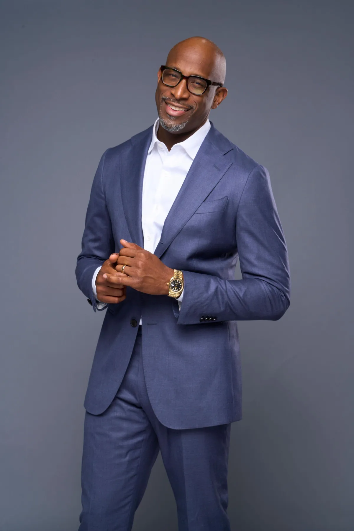 A diverse group of entrepreneurs in lively discussion on a podcast set, microphones and headphones visible, with a dark, moody background and warm orange accent lighting. The scene feels energetic, collaborative, and focused on sharing insights.
