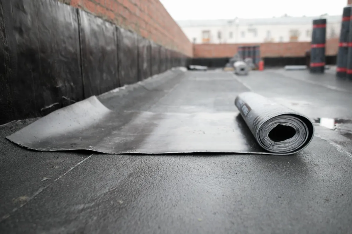 a roll of black tarp on a black roof