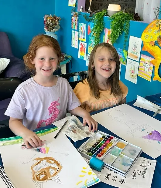 Square portrait of colorful collage work in progress with scissors, paste, and vibrant paper scraps—close-up composition with strong color pops.