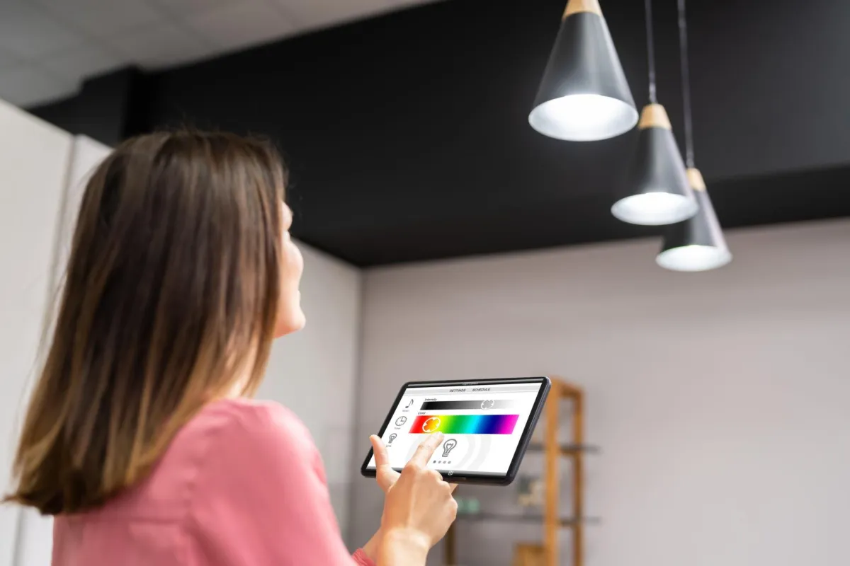 A woman using a tablet to adjust the temperature of Office lighting