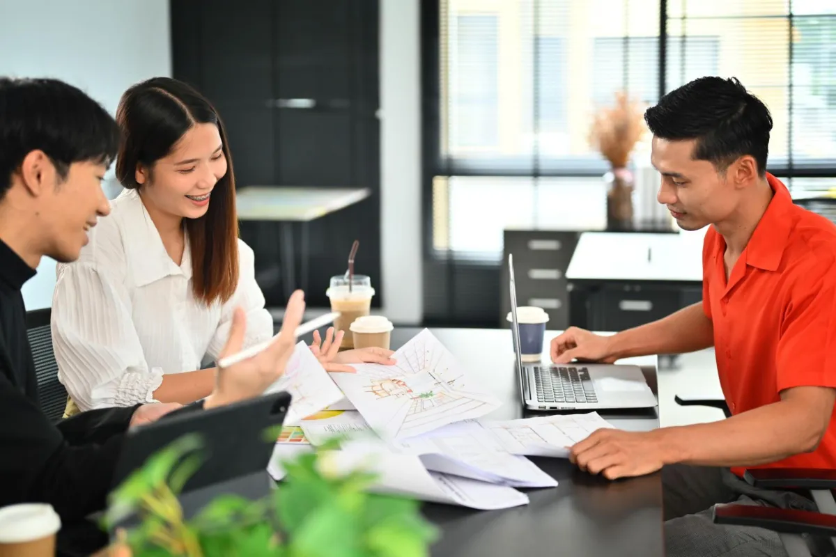 Office workers meeting at a desk discussing lighting design