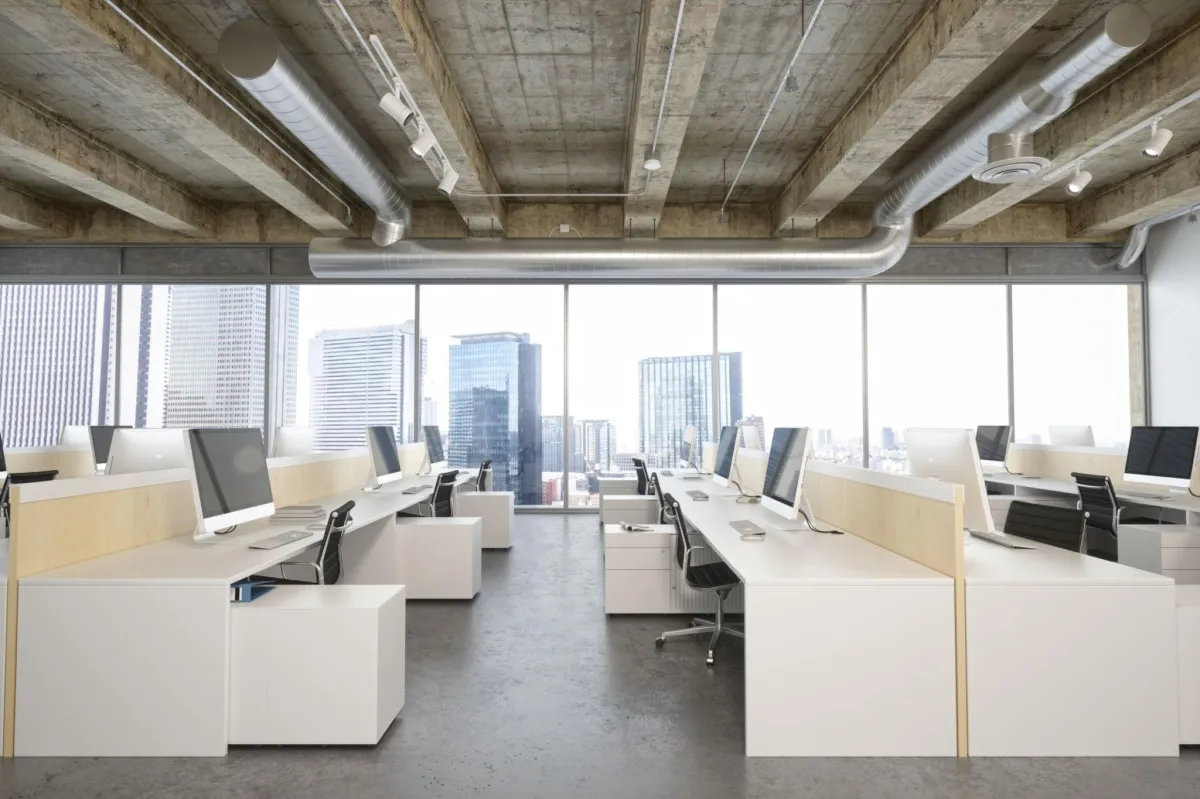 a city office full of computer desks, a larger ventilation system overhead