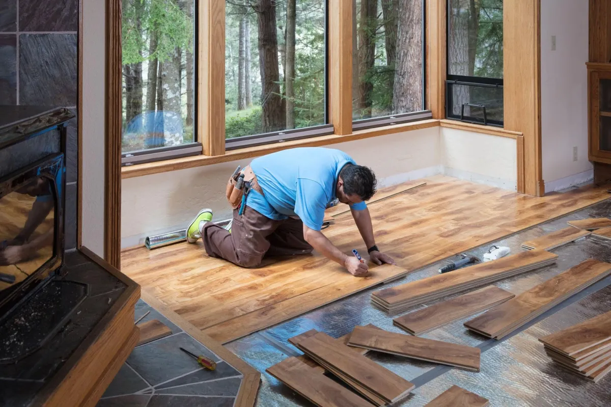 man installing wood floor planks