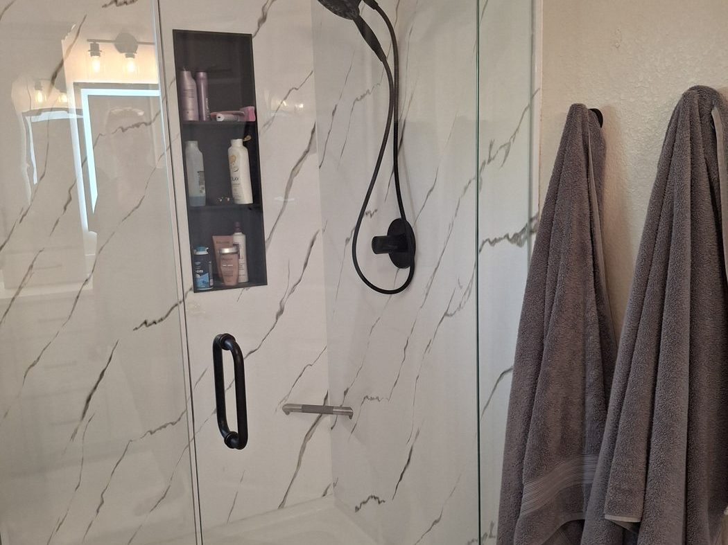 Custom tile shower with marble-look walls and black fixtures