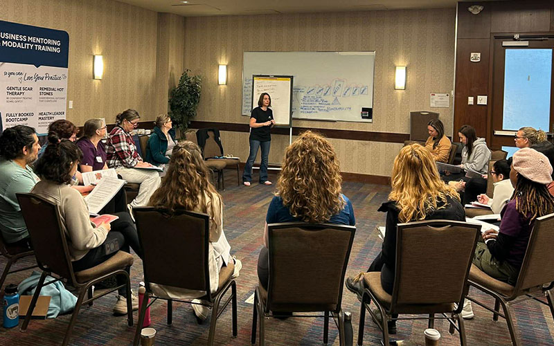 Christine teaching massage skills and theory