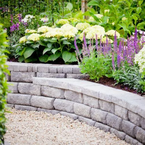 stone wall with a garden behind it