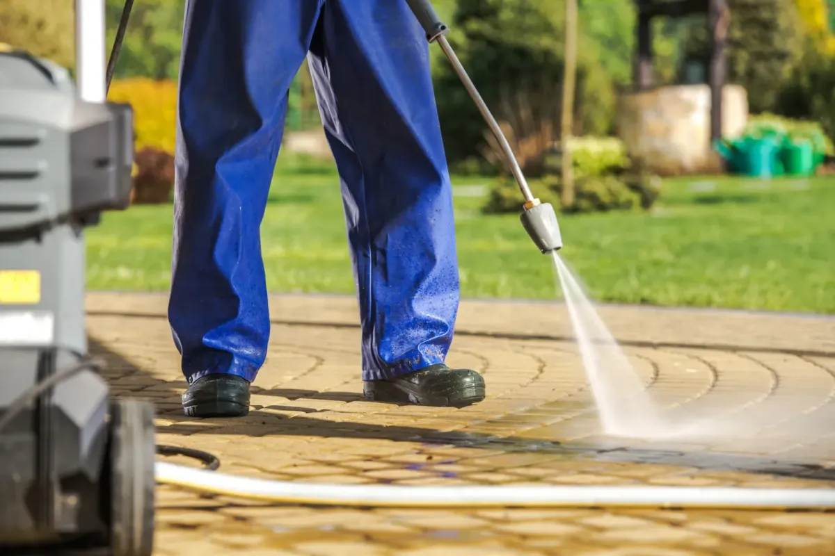 pressure washing Novato, CA — technician cleaning driveway with surface cleaner — A & J Yard Service