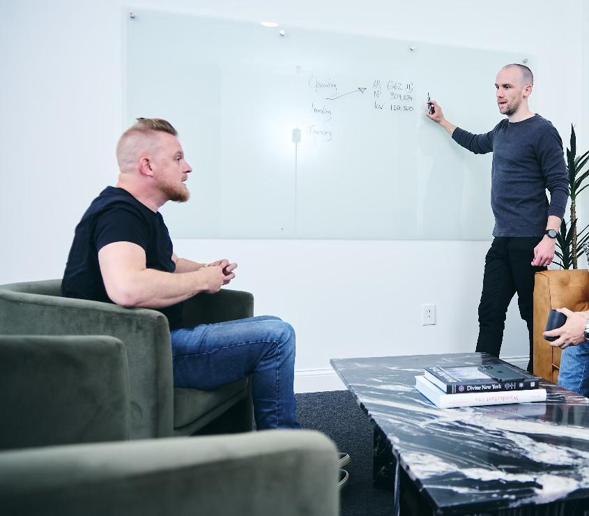 Person using calculator at desk with computer charts.