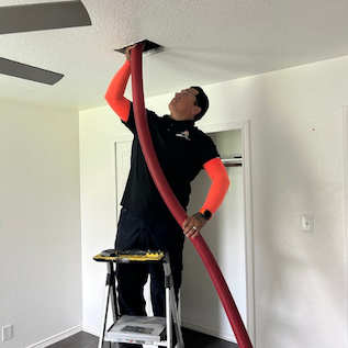 HVAC technician cleaning and repairing air ducts inside a home in New Braunfels, TX