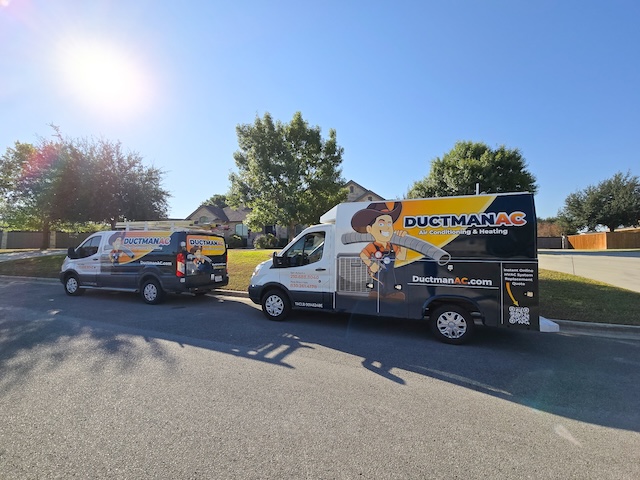 Ductman AC Air Conditioning & Heating service vans parked in a New Braunfels neighborhood, ready for HVAC repair and installation across San Antonio and surrounding areas.