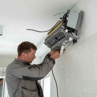 Professional HVAC technician installing a new mini-split air conditioning system for efficient home cooling in New Braunfels and San Antonio, TX