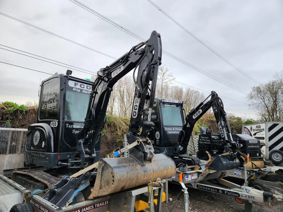 black car parked beside green trees during daytime
