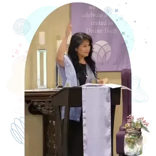 Women standing at a podium with an open book in a room with spiritual