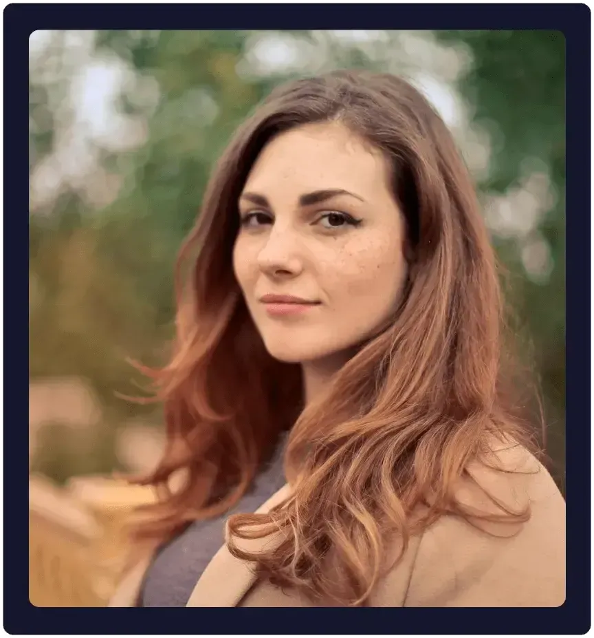Woman looking directly at the camera with a calm, confident expression, representing self-trust and readiness to heal her money story