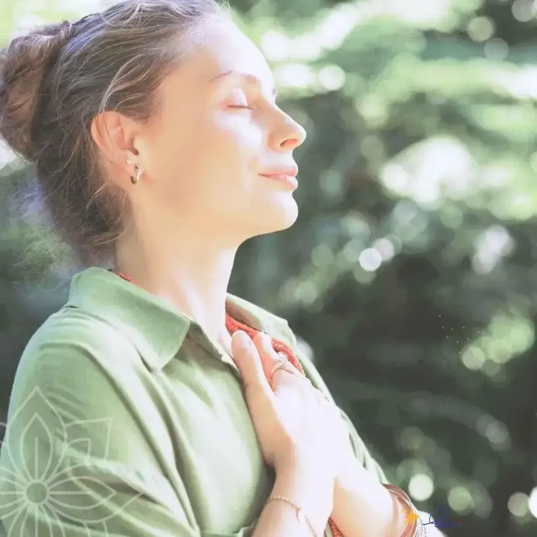 woman with hand on heart surrounded by warm light — supported by sisterhood and divine compassion in the Money Detox journey