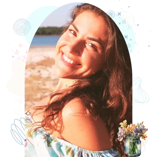 A girl with shoulder-length hair wearing a floral top, by the beach