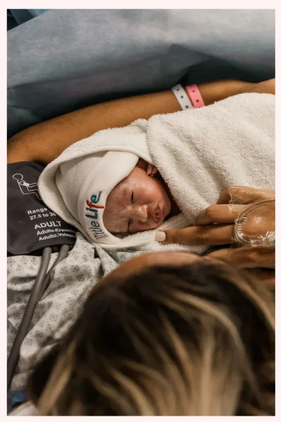 Image of a baby being held by its mother, shortly after being born by c-section. Image corresponds with a list of what is included in private birth education classes in Minneapolis and Saint Paul, Minnesota.