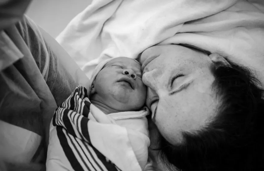 Image of mother and baby touching cheek to cheek after a c-section birth. Image supports testimonial from Laura in Minneapolis, MN.