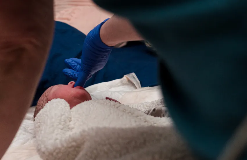 An IBCLC checks a newborn for a tongue tie