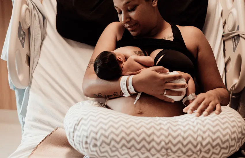 Image of a newborn baby, lying on a bed, after being born in a doula supported birth in the Twin Cities of Minneapolis and Saint Paul, Minnesota.